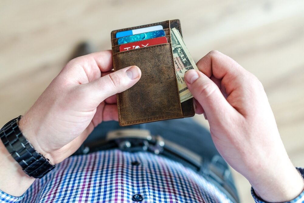 Un homme utilisant un porte carte qu'il préfère à un gros portefeuille